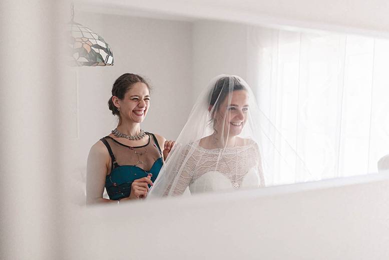 Hochzeitreportage, Foto von Getting Ready Braut im Kleid mit einer Freundin