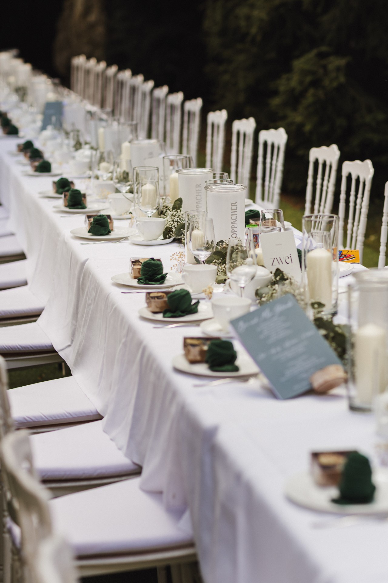 Lachende Gäste und Anschneiden der Torte im Garten der Hochzeitskapelle Callenberg (Sachsen).