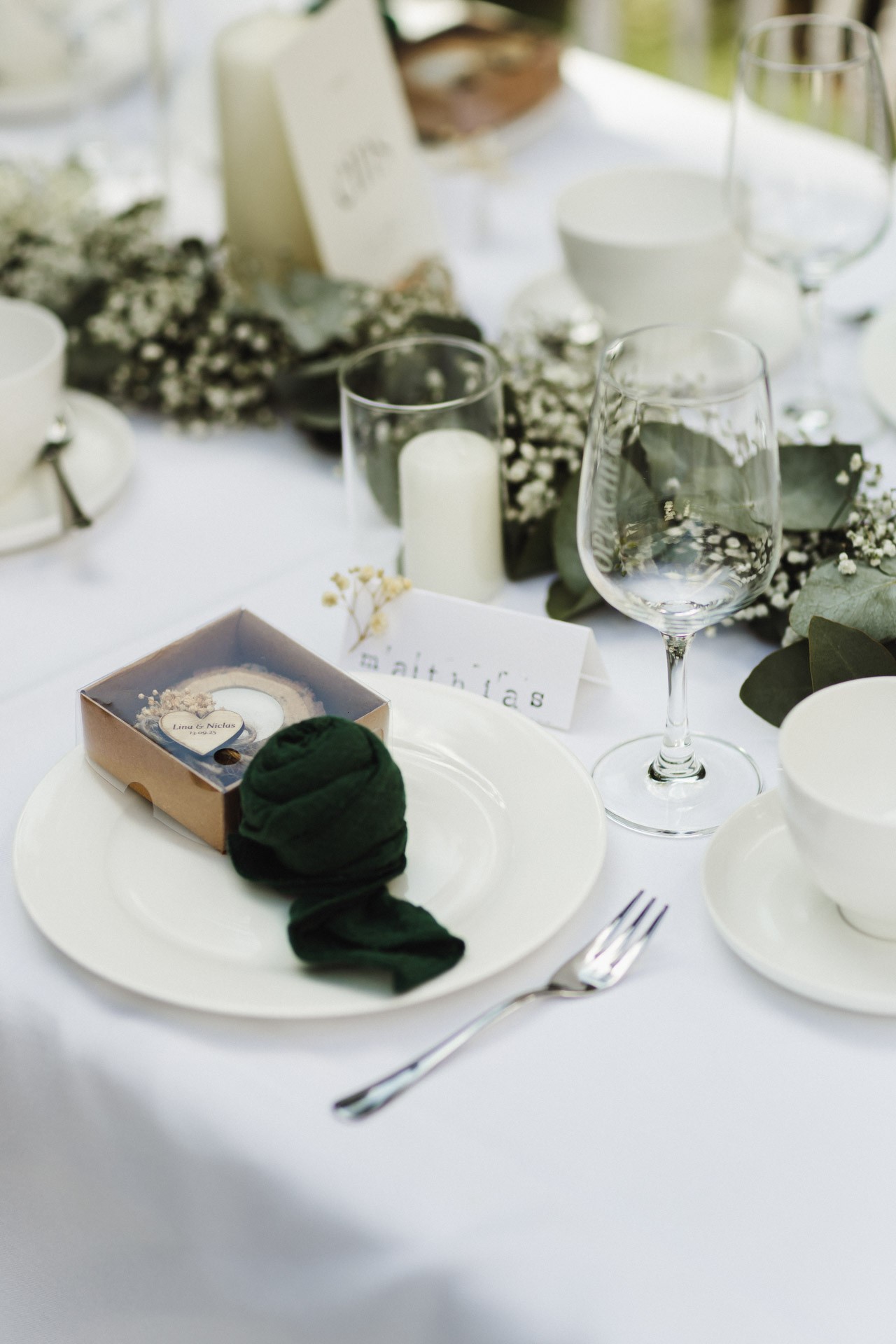 Lachende Gäste und Anschneiden der Torte im Garten der Hochzeitskapelle Callenberg (Sachsen).