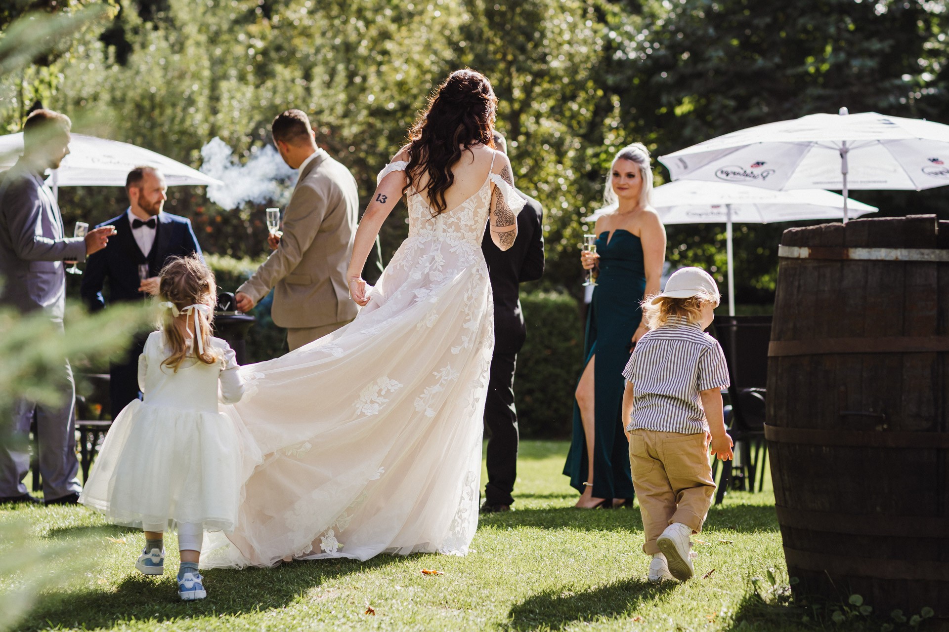 Lachende Gäste und Anschneiden der Torte im Garten der Hochzeitskapelle Callenberg (Sachsen).