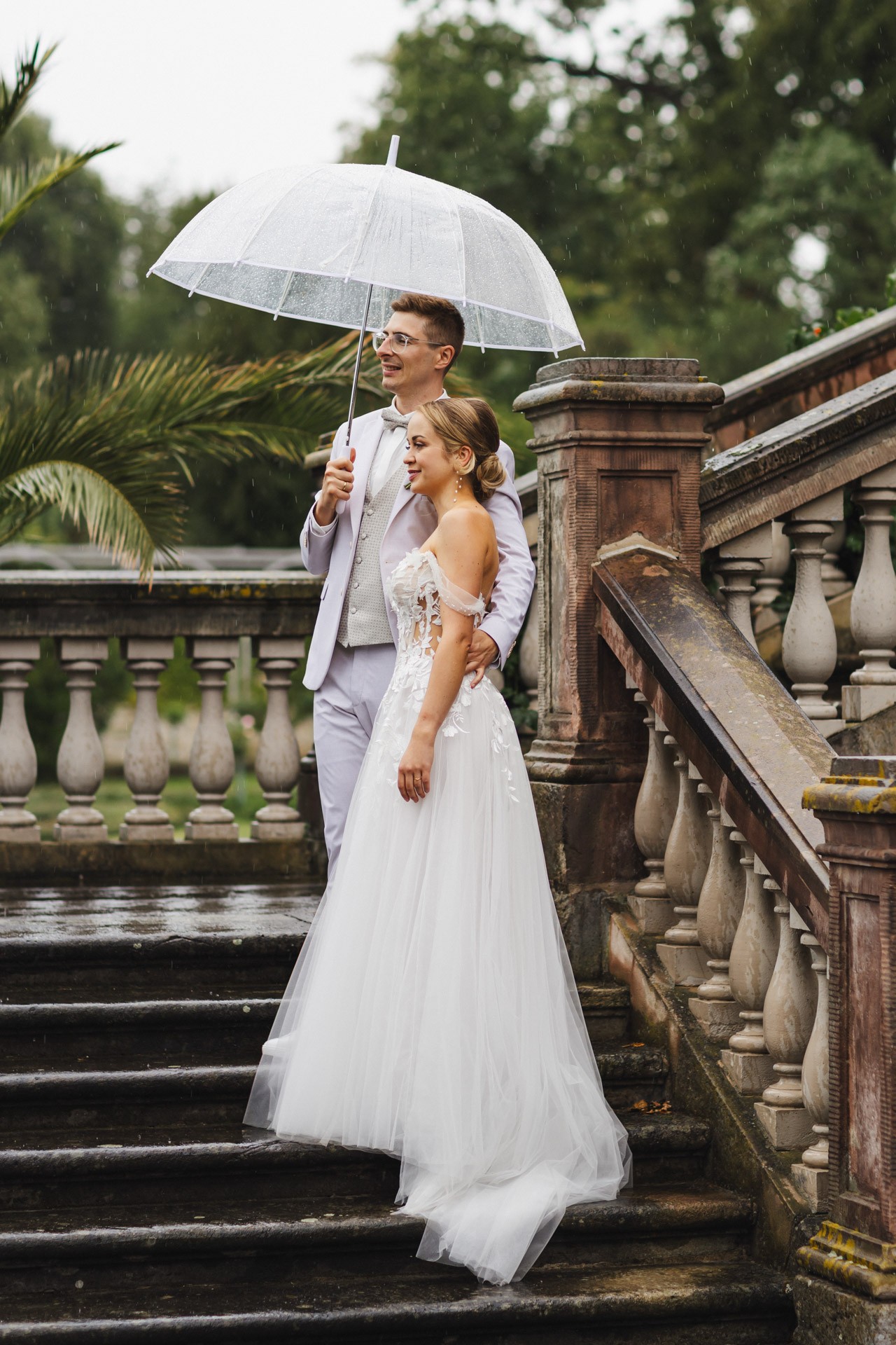 Brautpaar lacht entspannt beim Paarshooting im Schlosspark Ettersburg bei Regen. Danach elegante Paarfotos und romantische Schleierportraits im Weißen Saal.