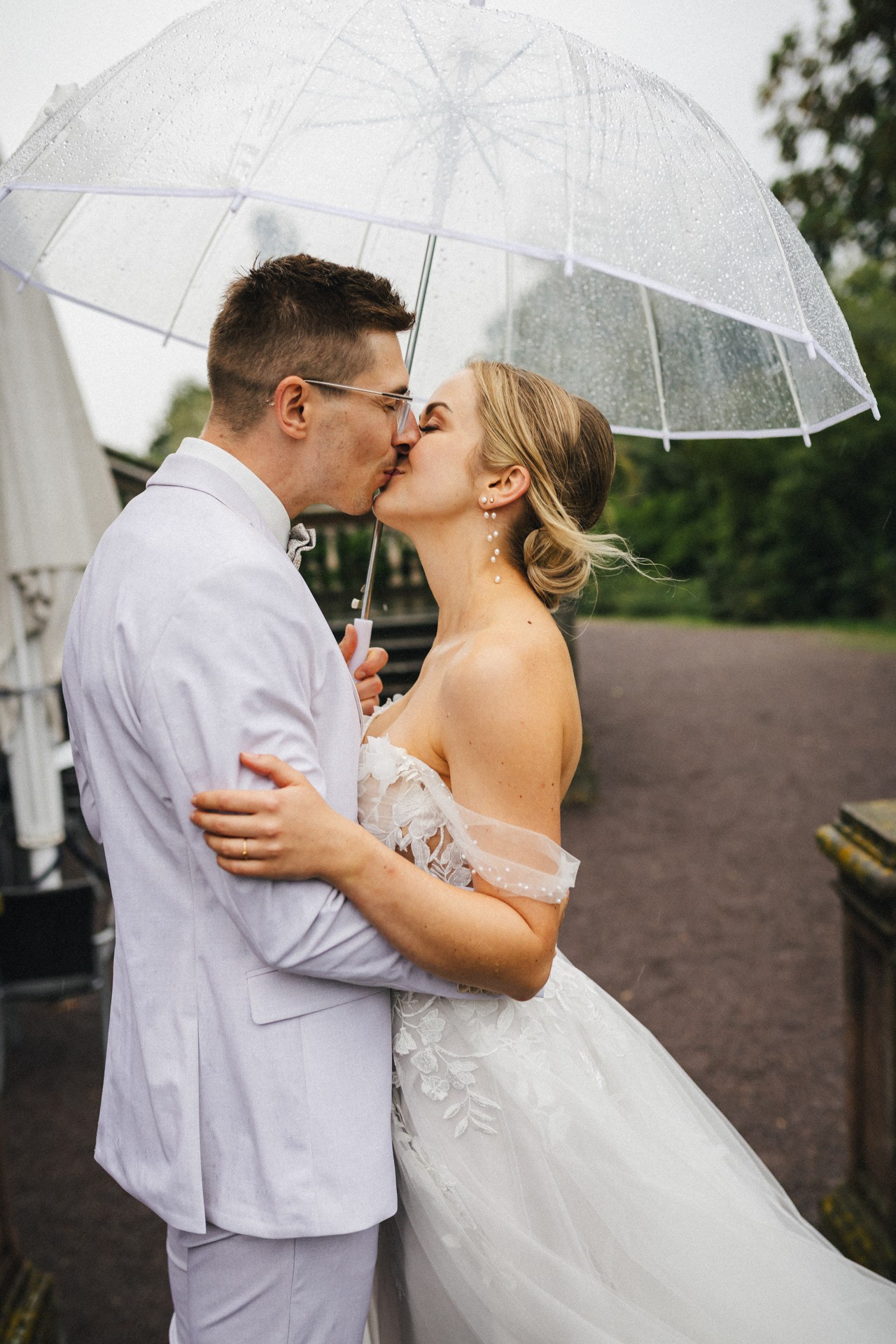 Brautpaar lacht entspannt beim Paarshooting im Schlosspark Ettersburg bei Regen. Danach elegante Paarfotos und romantische Schleierportraits im Weißen Saal.